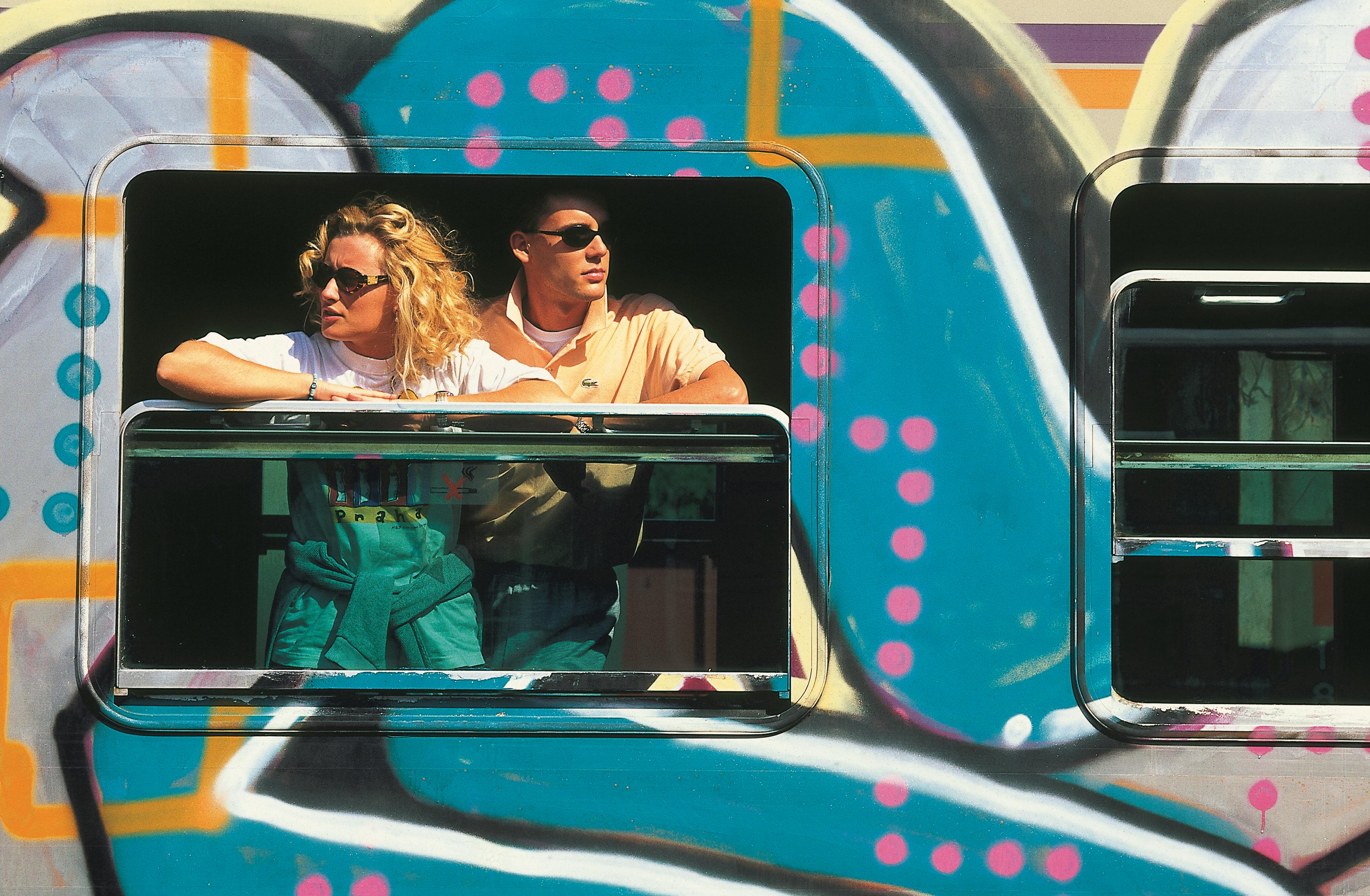 A couple gazing out of a train window, reflecting a moment of travel and introspection